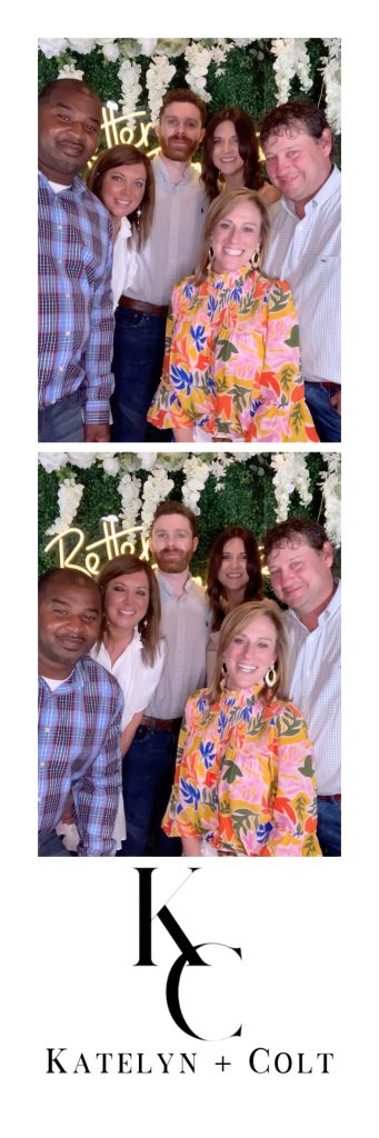 A printed 2x6 photo strip with two images, hedge and white flower floral wall, and Better Together neon sign at a wedding in Northwest Arkansas where the photo booth was rented.